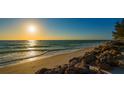 Scenic beach view at sunset with calm waves and rocks at 3858 Casey Key, Nokomis, FL 34275