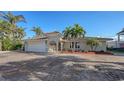 Well-maintained house with a white garage door and palm trees at 3858 Casey Key, Nokomis, FL 34275