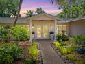 Inviting home exterior featuring a walkway, lush landscaping, and double front doors at 5140 Windward Ave, Sarasota, FL 34242