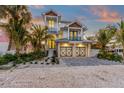Two-story house with light blue metal roof, two-car garage, and landscaped yard at 518 Spring Ave, Anna Maria, FL 34216