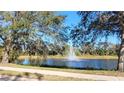 Serene pond with fountain, lush trees, and a walking path at 5649 Key Largo Ct, Bradenton, FL 34203