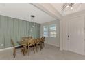 Dining room with wooden table, six chairs, and a green accent wall at 5755 Woodland Sage Dr, Sarasota, FL 34238