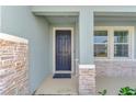 House entrance with dark gray door, stone accents, and two windows at 5755 Woodland Sage Dr, Sarasota, FL 34238