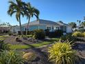 Side view of light blue home showcasing landscaping and palm trees at 618 Jungle Queen Way, Longboat Key, FL 34228