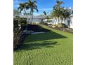 Landscaped front yard with artificial turf and tropical plants at 618 Jungle Queen Way, Longboat Key, FL 34228
