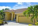 Single-story home with a tile roof, neutral color, and landscaping at 7596 Palmer Glen Cir, Sarasota, FL 34240