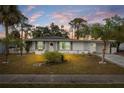 White single story home with palm trees and a landscaped yard at dusk at 8142 Coco Solo Ave, North Port, FL 34287