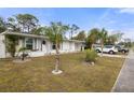 Side view of a white single story home with palm trees and a landscaped yard at 8142 Coco Solo Ave, North Port, FL 34287