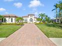 Mediterranean-style home with paver driveway and mature landscaping at 11740 Rive Isle Run, Parrish, FL 34219