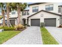 Two-story townhome with gray double garage doors and landscaped front yard at 15127 Lyla Ter, Bradenton, FL 34211