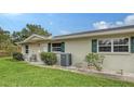 Side view of tan house with green accents and a well-manicured lawn at 2621 Golf Course Dr # 401, Sarasota, FL 34234