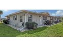 Corner view of a tan house with green accents and neatly landscaped yard at 2621 Golf Course Dr # 401, Sarasota, FL 34234