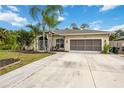 Single-story house with palm trees, landscaped lawn, and a large driveway at 3506 Culpepper Ter, North Port, FL 34286