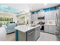 Open concept kitchen with stainless steel appliances and island at 3922 Wildgrass Pl, Parrish, FL 34219