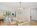 Bright dining area with glass table and pink chairs, open to living room at 3987 Maceachen Blvd # 123, Sarasota, FL 34233