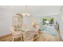 Charming condo dining area with glass table and pink chairs at 3987 Maceachen Blvd # 123, Sarasota, FL 34233