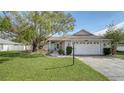 Cute one-story house with a white garage door and green lawn at 5687 Milton Ave, Sarasota, FL 34243