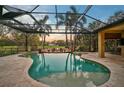 Inviting freeform pool and spa with covered patio and sunset views at 654 Trenton Way, Osprey, FL 34229