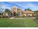 Two-story house with tile roof, lush landscaping, and a paved walkway at 6919 Winners Cir, Lakewood Ranch, FL 34202