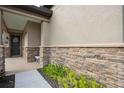 Front entry with stone accents, a charming door, and manicured landscaping at 715 116Th Ne Ct, Bradenton, FL 34212