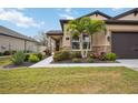 House exterior showcasing walkway, landscaping, and partial garage view at 715 116Th Ne Ct, Bradenton, FL 34212