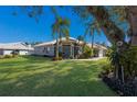 One-story home with lush landscaping and palm trees at 7203 41St E Ct, Sarasota, FL 34243