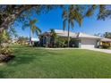 Green house with white garage door and lush landscaping at 7203 41St E Ct, Sarasota, FL 34243