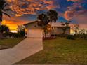 Single story home with a gorgeous sunset in the background at 10428 Marion St, Englewood, FL 34224