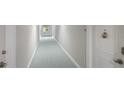 Clean and bright hallway with light teal carpet at 1212 Benjamin Franklin Dr # 305, Sarasota, FL 34236