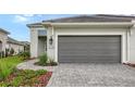 Gray garage door and paved walkway leading to house entrance at 12649 Palatka Dr, Venice, FL 34293