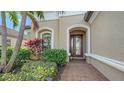 Inviting entryway with a red door and brick walkway at 13947 Messina Loop, Bradenton, FL 34211