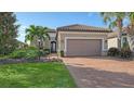 One-story home with tile roof, two-car garage, and landscaped yard at 13947 Messina Loop, Bradenton, FL 34211