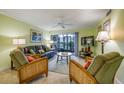 Living room with tiled floors, leather couches, and access to patio at 1801 Gulf N Dr # 175, Bradenton Beach, FL 34217