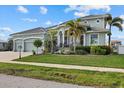 Two-story house with three-car garage, palm trees, and manicured lawn at 210 Beeney Se Rd, Port Charlotte, FL 33952