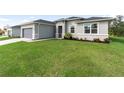 One-story home with gray siding, gray roof, and landscaping at 3411 Dryden St, North Port, FL 34288