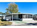 White manufactured home with carport and landscaped yard at 3411 Spanish Oak Ter, Sarasota, FL 34237