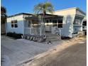 Light blue mobile home with covered porch and palm tree at 3710 Gulf Of Mexico Dr # G-6, Longboat Key, FL 34228