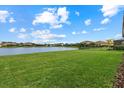 Spacious backyard with a lake view and lush green grass at 3713 Savanna Palms Ct, Bradenton, FL 34211