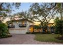 Luxury waterfront home with three-car garage, mature landscaping, and brick driveway at 3930 Red Rock Way, Sarasota, FL 34231