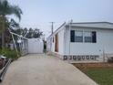 Front view of a white mobile home with a shed and driveway at 4969 Pebble Beach Ave, Sarasota, FL 34234