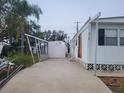 Front view of a white mobile home with a shed and driveway at 4969 Pebble Beach Ave, Sarasota, FL 34234