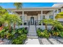 Modern home's front entrance with covered porch and lush landscaping at 505 69Th St, Holmes Beach, FL 34217