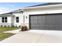 Two car garage with gray door and light gray concrete driveway at 5595 Delight Ave, North Port, FL 34288