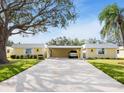 Bright yellow home exterior with carport and nicely landscaped lawn at 5826 Driftwood Pl # 34, Sarasota, FL 34231