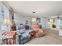 Bright living room with comfy armchairs and view to kitchen at 6045 Slade Rd, North Port, FL 34287