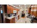 Well-equipped kitchen with wood cabinets and tile backsplash at 616 Pawn Way, Seffner, FL 33584