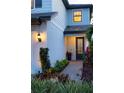 Well-lit entryway with landscaped walkway leading to front door at 6299 Crested Eagle Ln, Nokomis, FL 34275