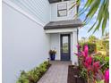 Front door entrance with brick walkway and colorful plants at 6299 Crested Eagle Ln, Nokomis, FL 34275