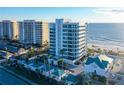 Aerial view of luxurious beachfront condo building with pool and ocean access at 655 Longboat Club Rd # 14A, Longboat Key, FL 34228