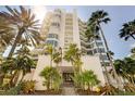 Stunning exterior of a modern beachfront condo building, surrounded by palm trees at 655 Longboat Club Rd # 14A, Longboat Key, FL 34228